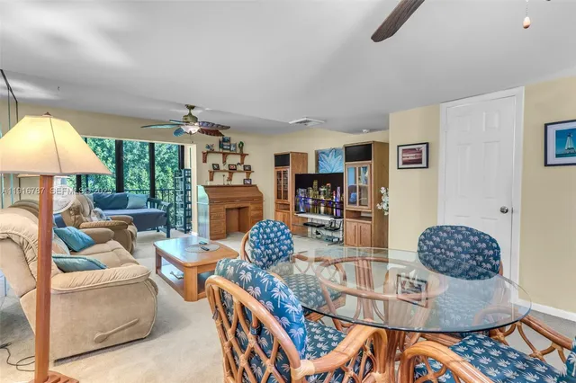 a view of a dining room and livingroom with furniture a chandelier and window