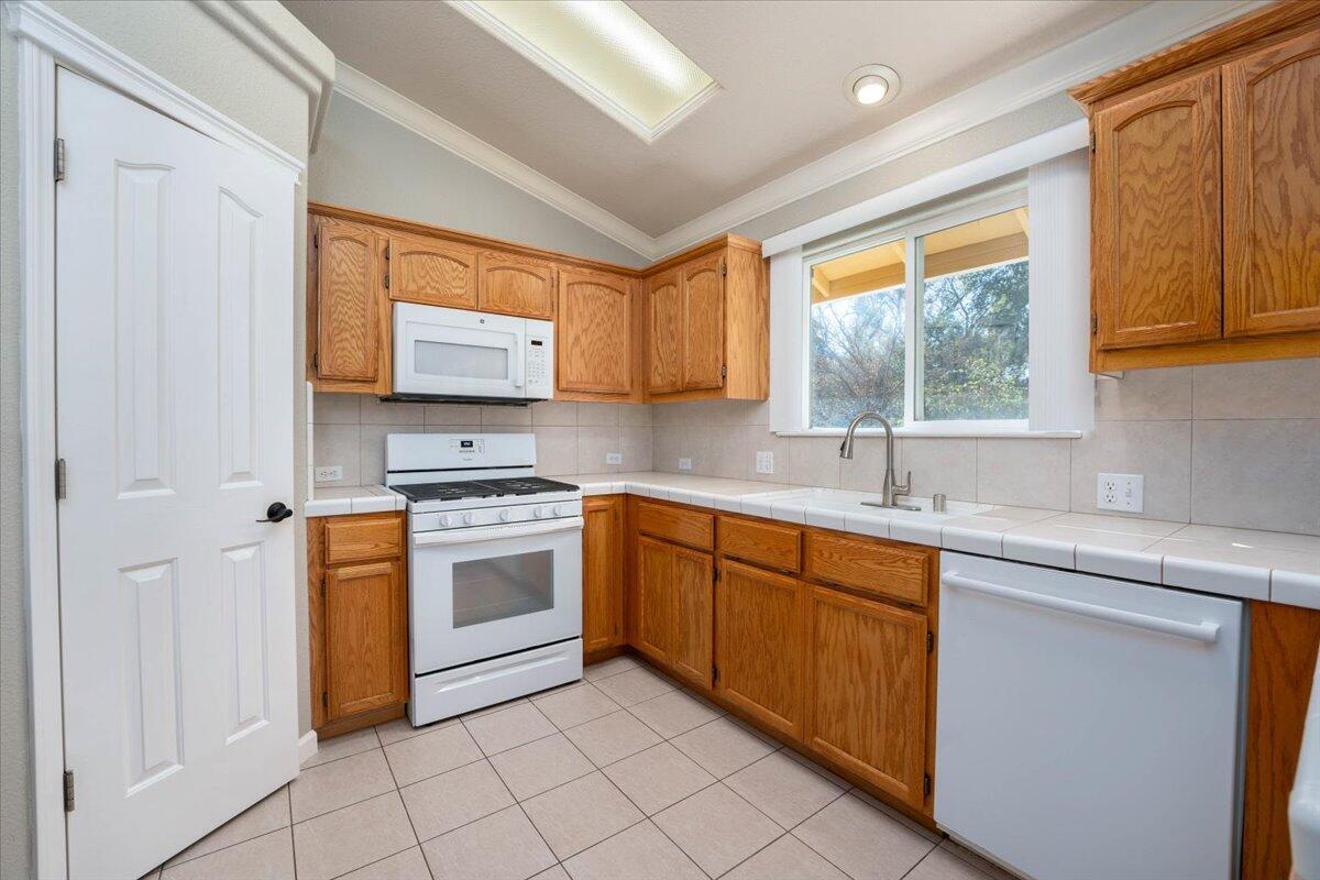 7704 Pit Road Redding, CA 96001 - Photo 11 of 34 a kitchen with stainless steel appliances granite countertop a stove sink and cabinets