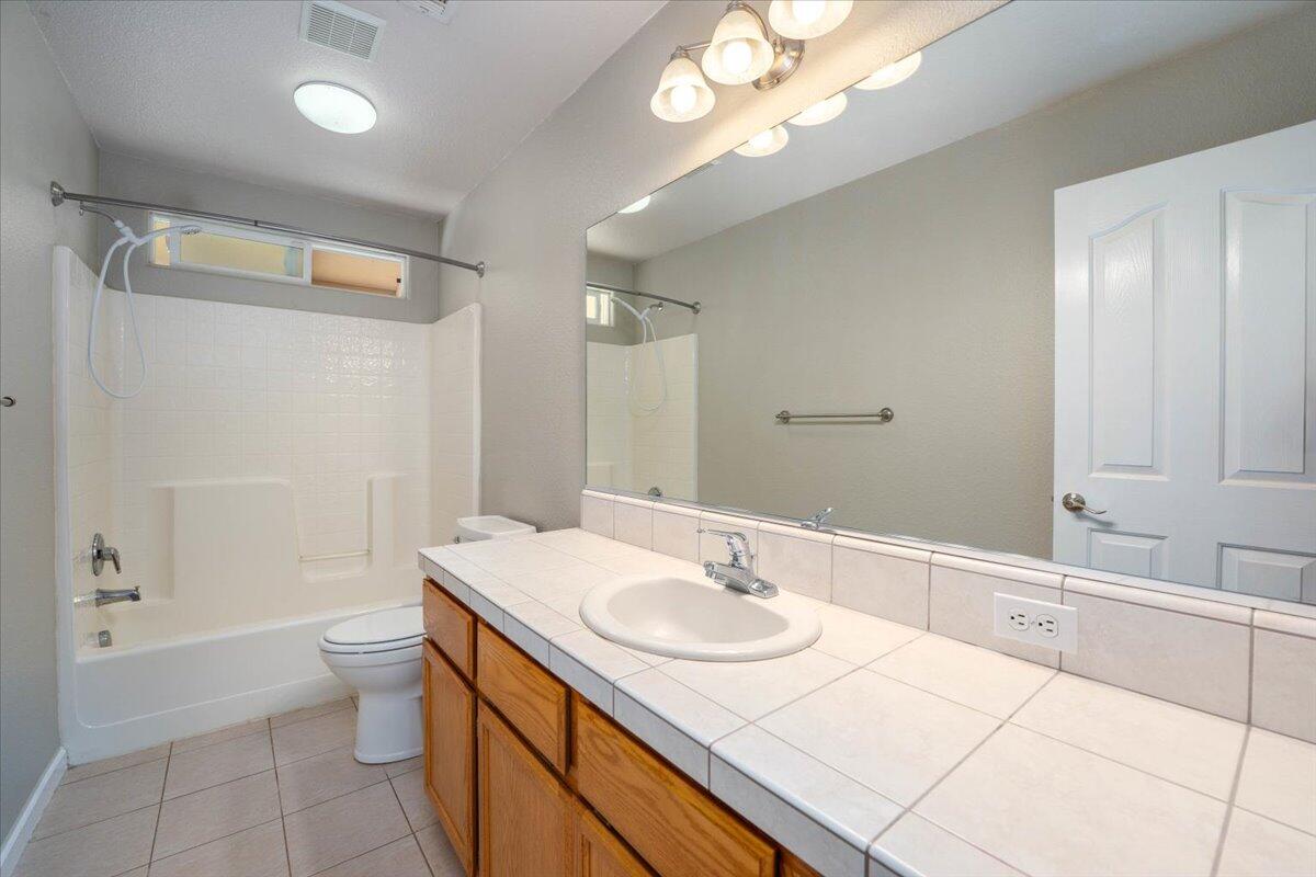 7704 Pit Road Redding, CA 96001 - Photo 23 of 34 a bathroom with a sink double vanity granite toilet and a bathtub