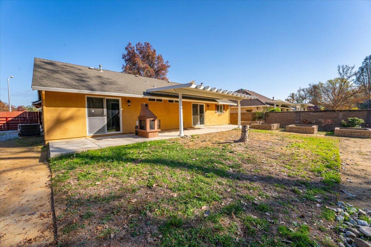 7704 Pit Road Redding, CA 96001 - Photo 32 of 34 a view of a house with backyard porch and garden