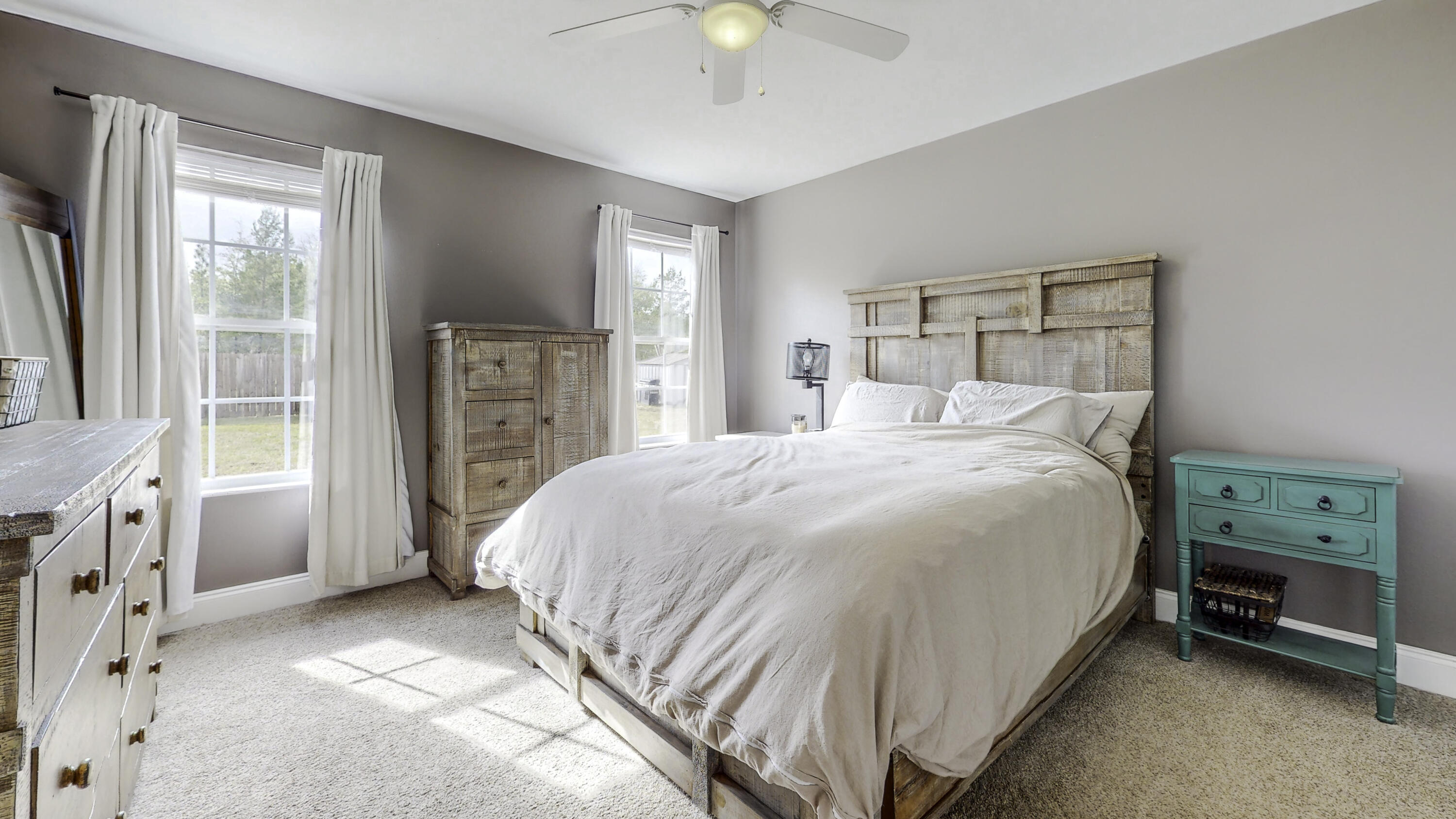 4696 Bobolink Way Crestview, FL 32539 - Photo 13 of 21 a bedroom with a bed a chandelier and a window