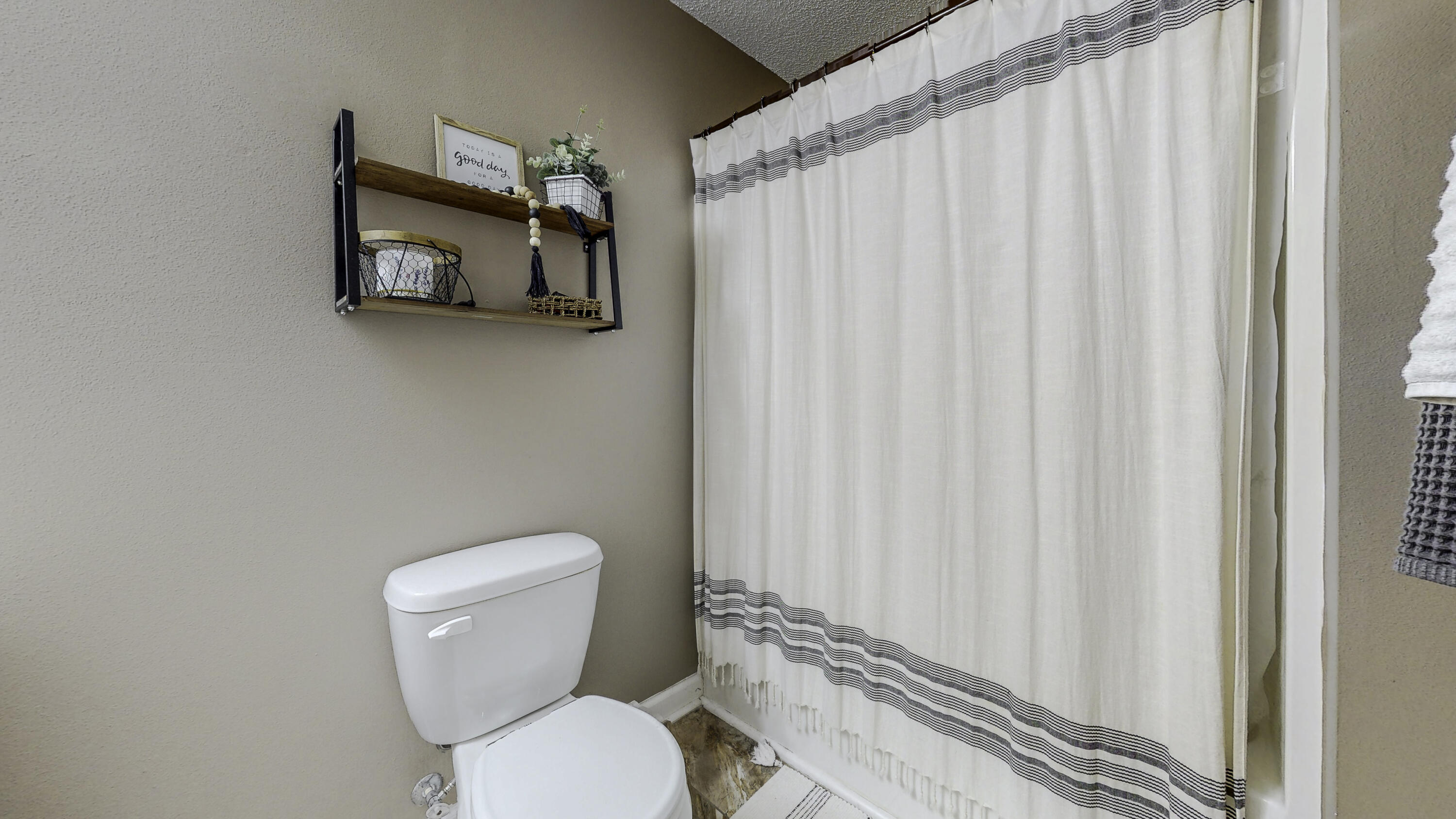 4696 Bobolink Way Crestview, FL 32539 - Photo 14 of 21 a white toilet sitting next to a shower curtain