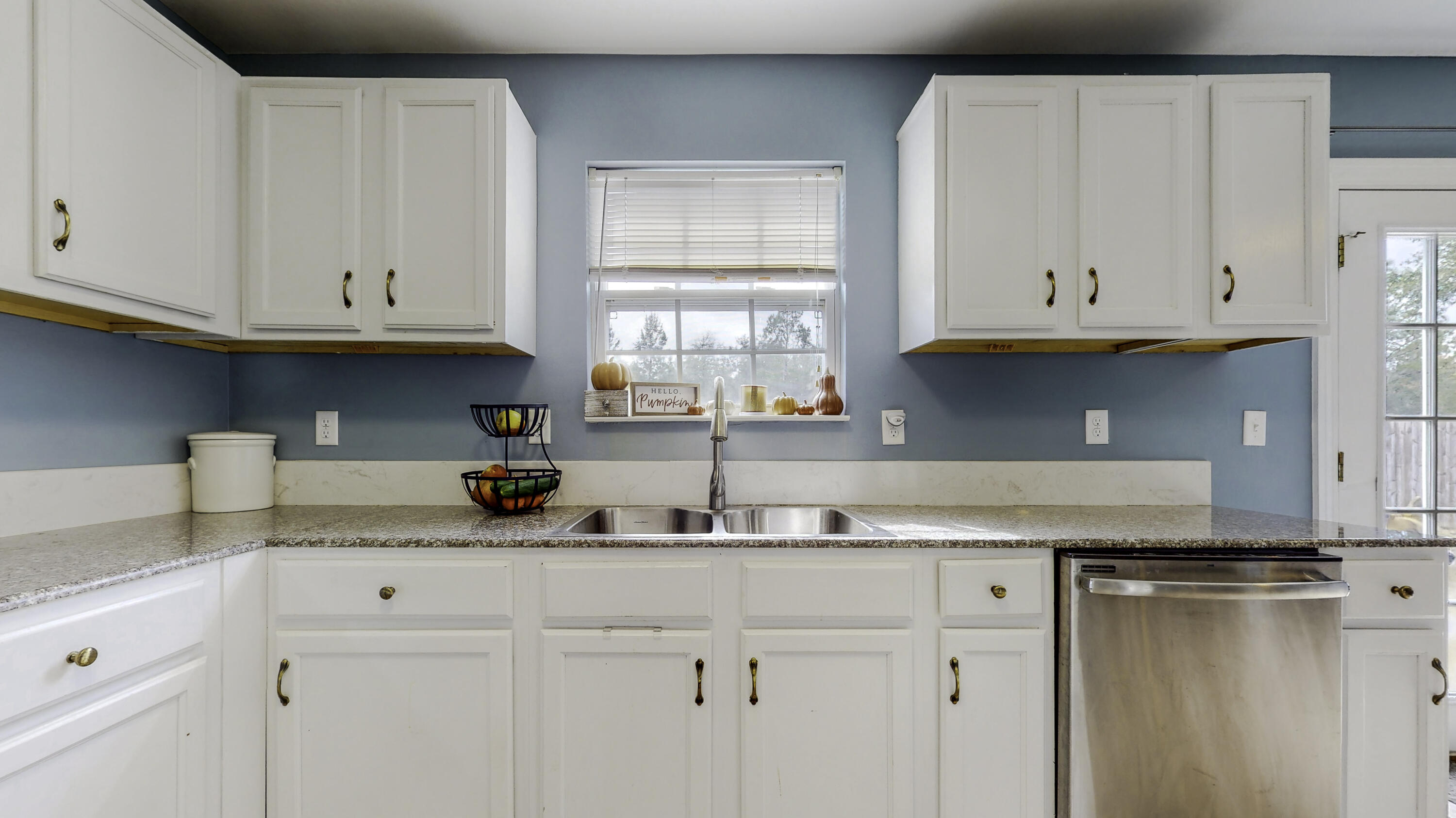 4696 Bobolink Way Crestview, FL 32539 - Photo 6 of 21 a kitchen with granite countertop a sink window and cabinets