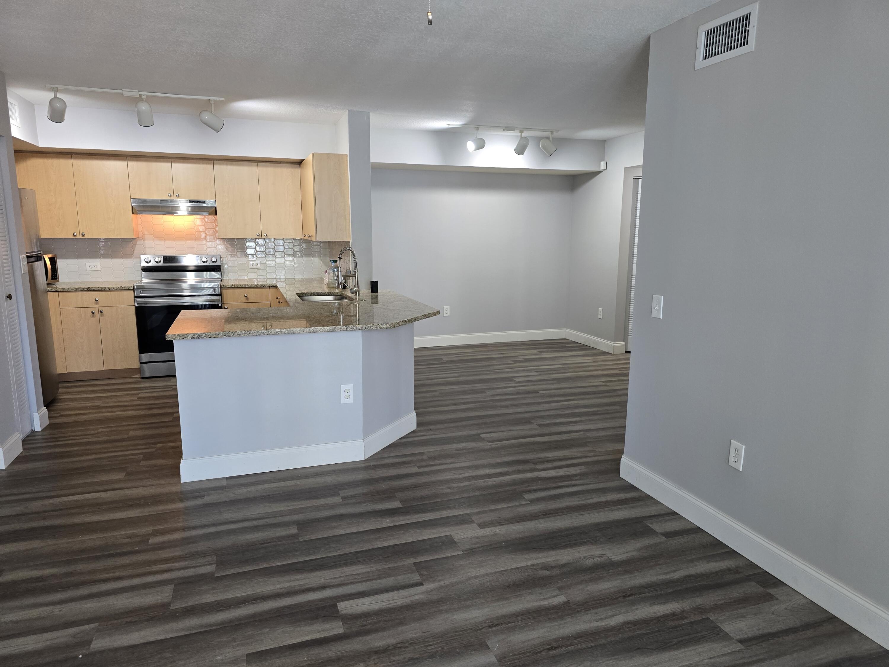 701 Villa Circle Boynton Beach, FL 33435 - Photo 4 of 17 a kitchen with kitchen island cabinets and wooden floor