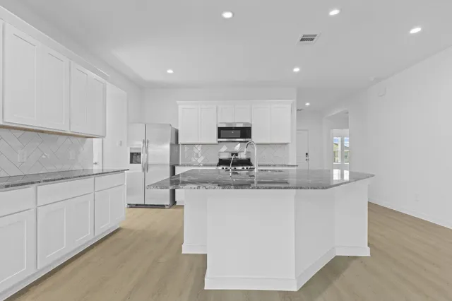a kitchen with stainless steel appliances granite countertop a sink and cabinets