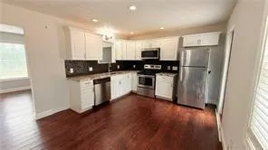 a kitchen with stainless steel appliances a refrigerator and wooden floor