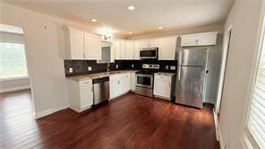 446 Russell Cemetery Road Winder, GA 30680 - Photo 11 of 40 a kitchen with stainless steel appliances a refrigerator and wooden floor