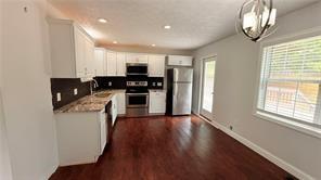 446 Russell Cemetery Road Winder, GA 30680 - Photo 12 of 40 a kitchen with stainless steel appliances granite countertop a stove and a refrigerator