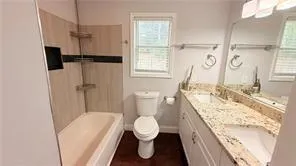 a bathroom with a granite countertop sink toilet and shower