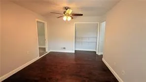 an empty room with closet and a chandelier fan