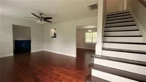 a view of a livingroom with wooden floor and stairs
