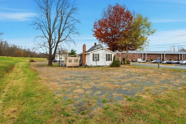 a view of a house with pool and trees in the background