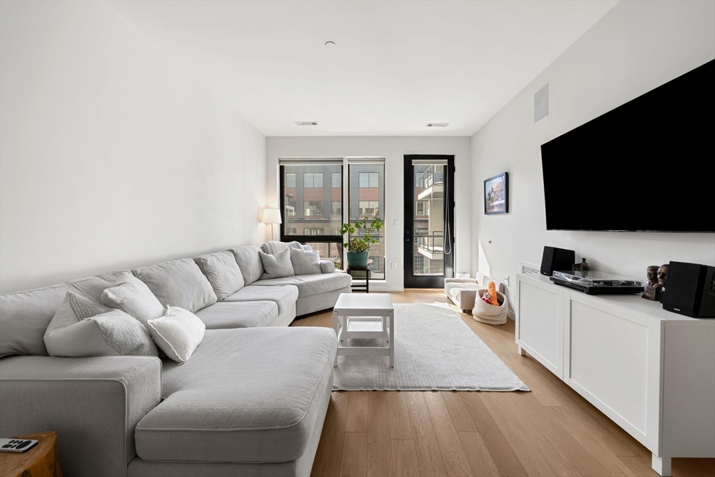 45 West 3rd Street, Unit 406 Boston, MA 02127 - Photo 2 of 14 a living room with furniture and a flat screen tv