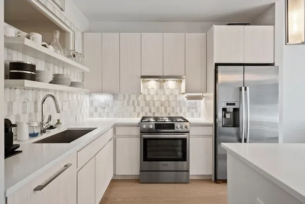 a kitchen with granite countertop white cabinets and stainless steel appliances