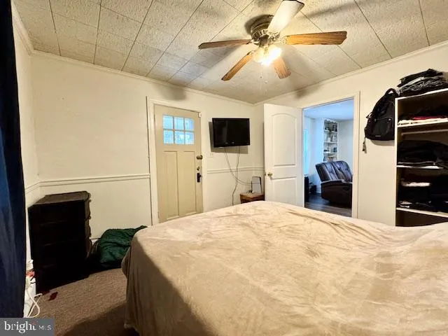 a bedroom with a bed and a flat tv screen on the dresser