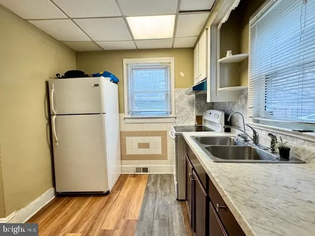 a kitchen with a sink a refrigerator and cabinets