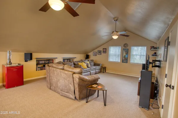 a living room with furniture a chandelier fan and a window