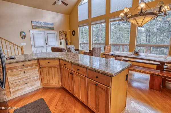 a kitchen with stainless steel appliances granite countertop a sink a stove and a wooden floors