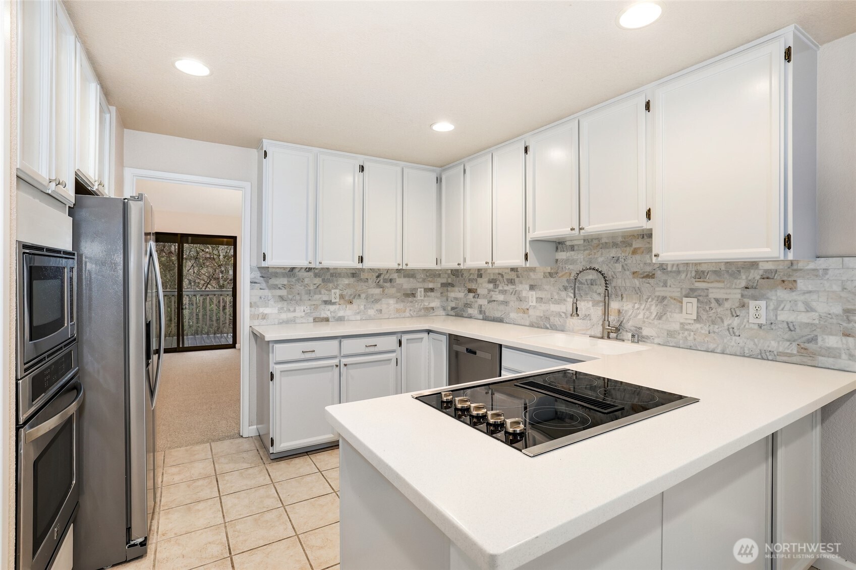 2940 Kennewick Place Northeast Renton, WA 98056 - Photo 8 of 37 a white kitchen with stainless steel appliances granite countertop a stove a sink and a refrigerator