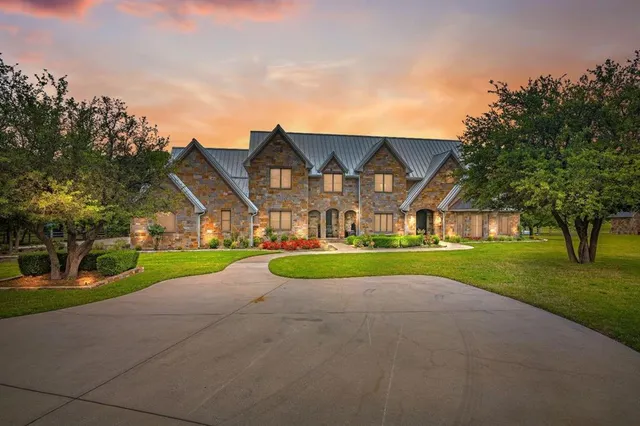 a view of house with a big yard and large trees