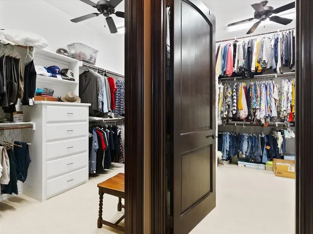 a view of walk in closet with clothes and shoes