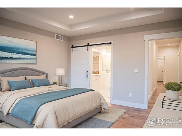 a bedroom with a bed and a painting on the wall