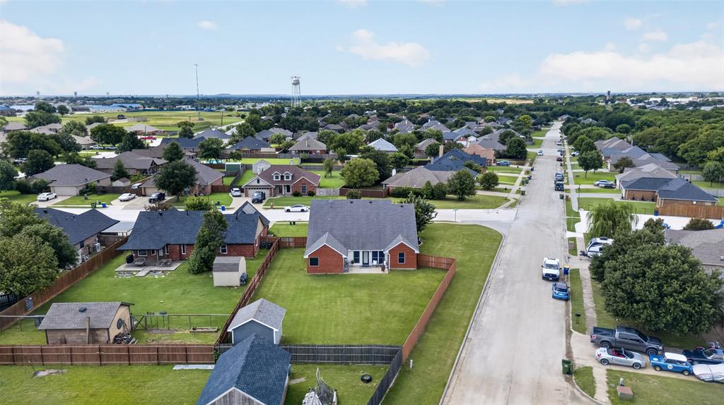 100 Radecke Road Krum, TX 76249 - Photo 4 of 29 Residential neighborhood featuring an array of single-story homes with dark roofs and mature trees lining the streets