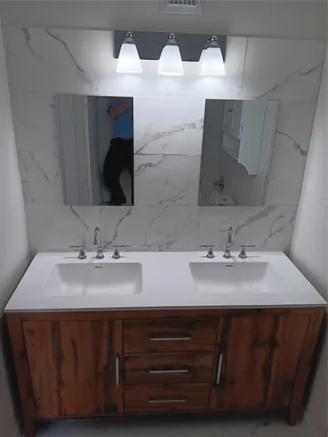 a bathroom with double vanity sinks and a mirror