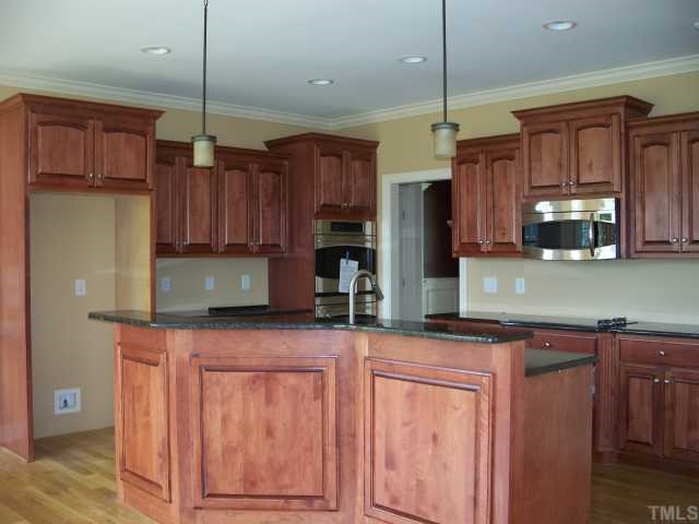 65 North Old Lantern Road Timberlake, NC 27583 - Photo 7 of 12 a kitchen with stainless steel appliances granite countertop wooden cabinets a sink and dishwasher