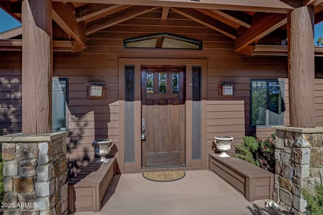 front view of a house with a potted plant and floor to ceiling window
