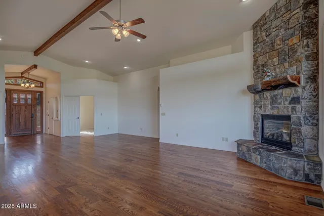 a view of a livingroom with wooden floor and a fireplace