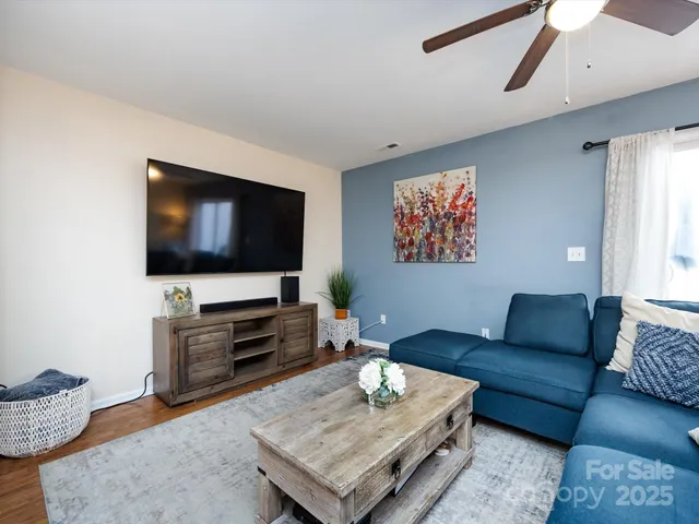 a living room with furniture ceiling fan and a window