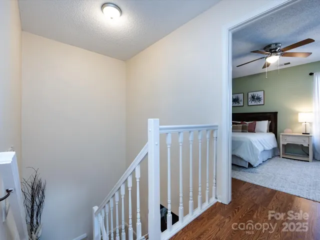 a bedroom with a bed a ceiling fan and a large window