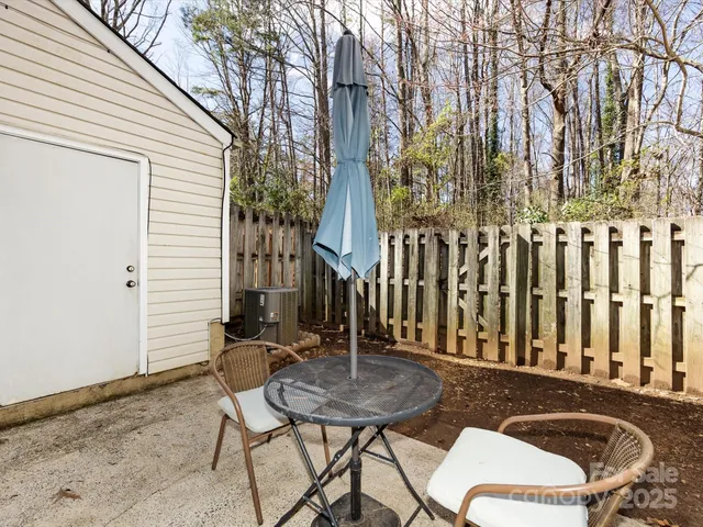a view of a white house with a yard and potted plants
