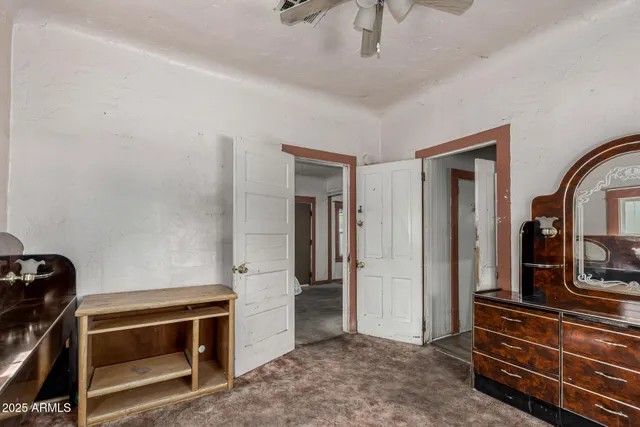 a view of room with wooden floor and a ceiling fan