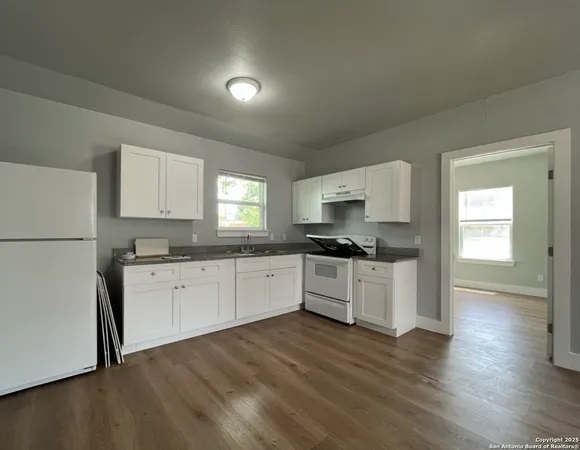 a kitchen with granite countertop white cabinets and white appliances