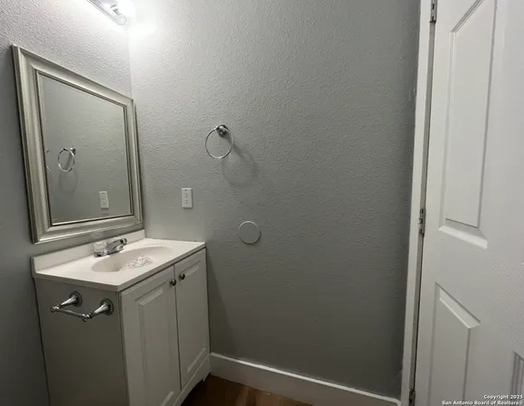 a bathroom with a sink and mirror with toilet