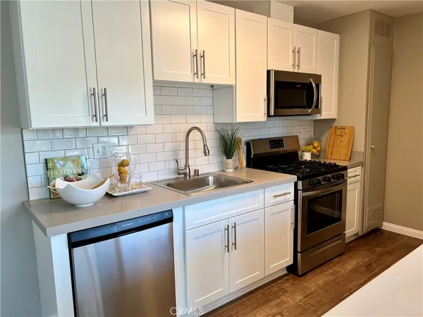 a kitchen with stainless steel appliances granite countertop a sink stove and microwave