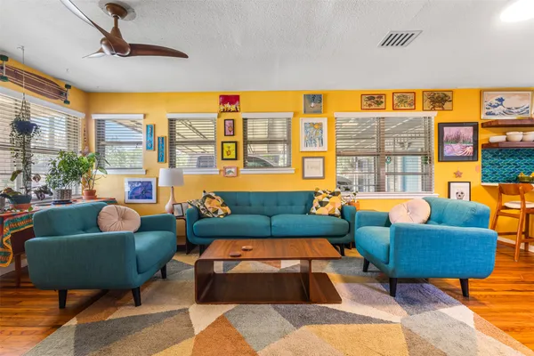 a living room with furniture a rug and a floor to ceiling window