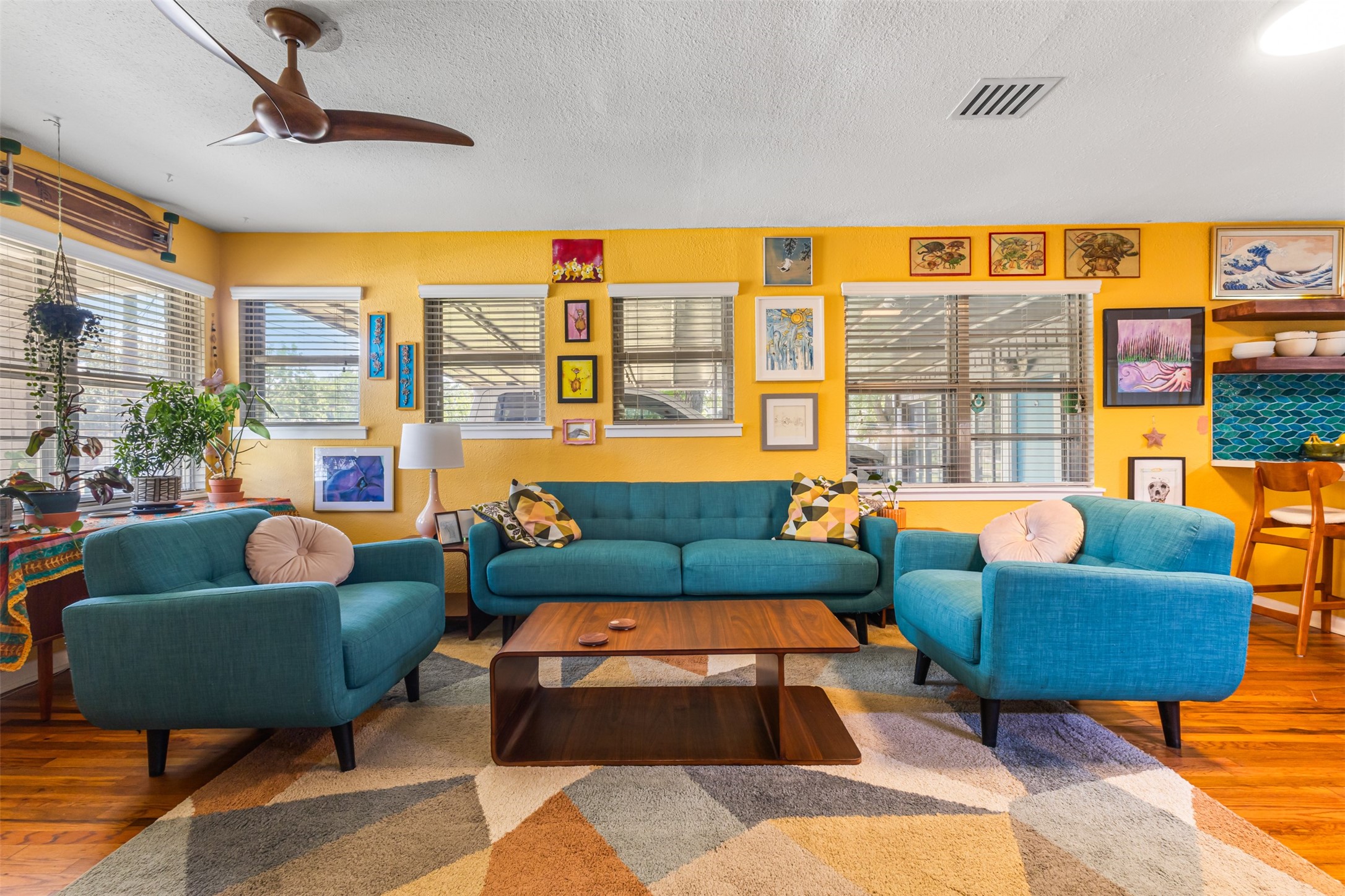 a living room with furniture a rug and a floor to ceiling window