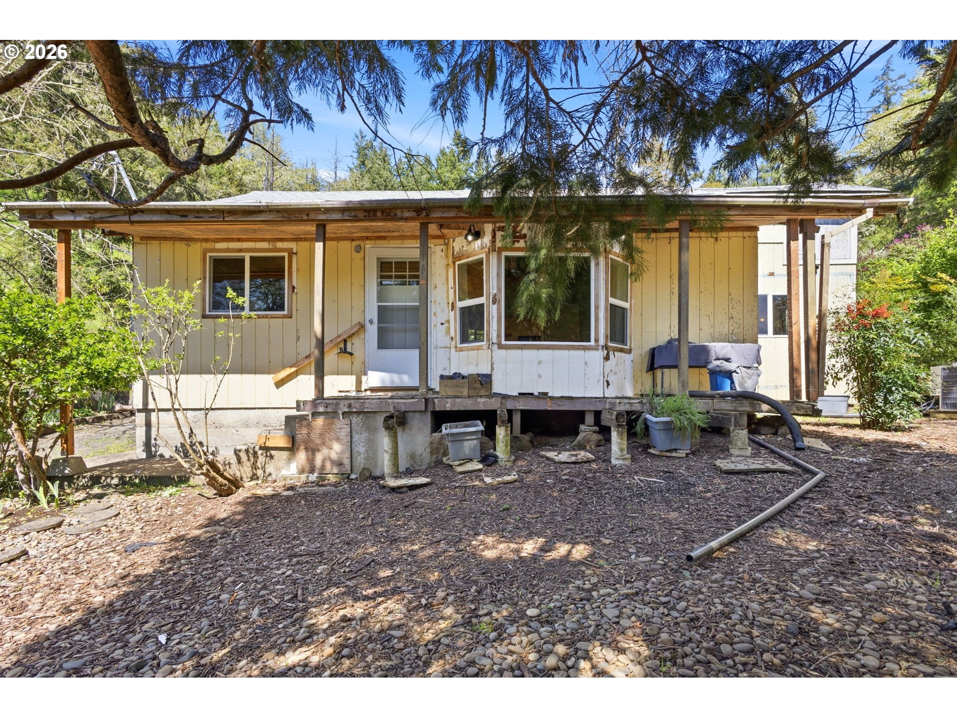 a backyard of a house with barbeque oven table and chairs