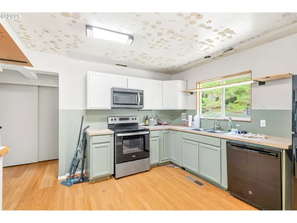 a kitchen with stainless steel appliances granite countertop a sink dishwasher stove and refrigerator