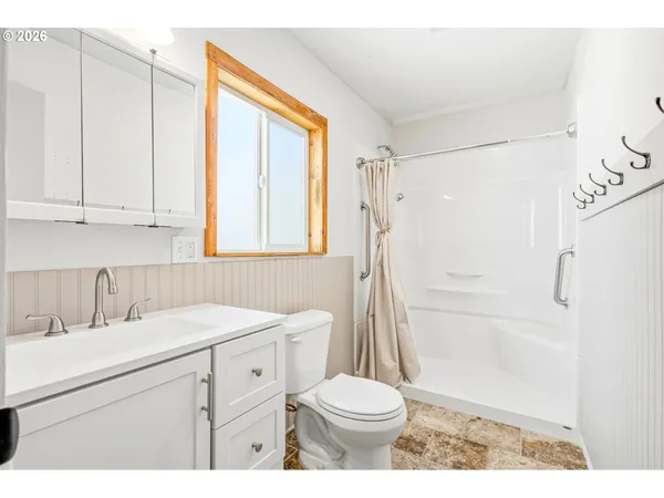 a bathroom with a sink a toilet and shower