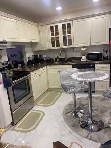 a kitchen with granite countertop a stove a sink and a granite counter tops