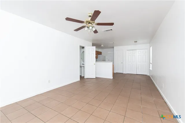 a view of a livingroom with a ceiling fan and window