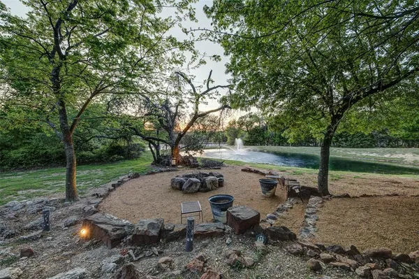 a view of backyard with table and chairs under an umbrella