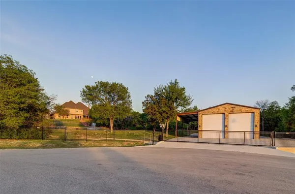 a view of a house with a big yard and large trees