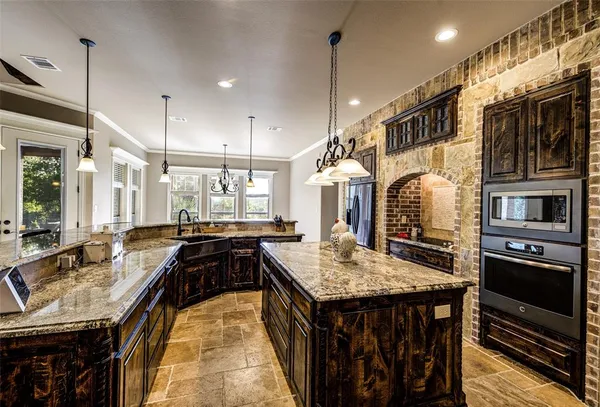 a kitchen with kitchen island granite countertop a stove and a sink