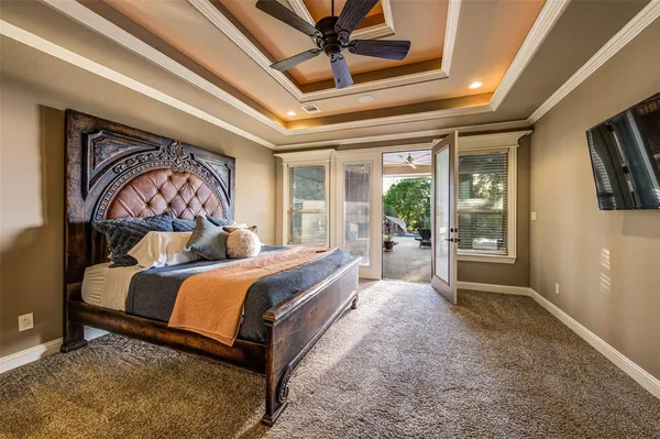 a bedroom with a large bed and a chandelier