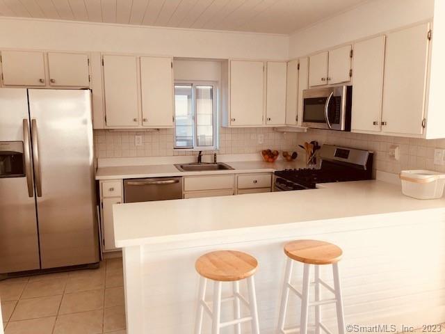 15 Merwin Avenue Milford, CT 06460 - Photo 9 of 23 a kitchen with stainless steel appliances granite countertop a sink a stove a refrigerator a washer and dryer